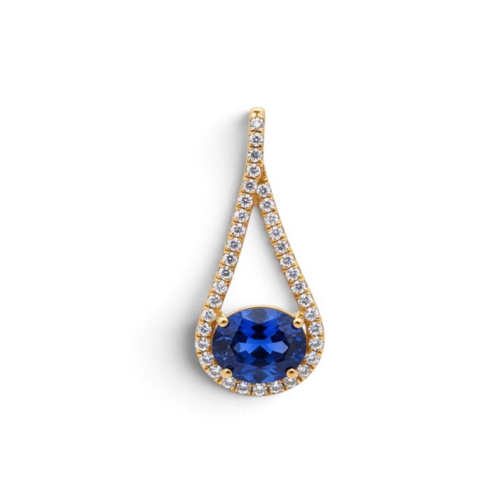 Caribbean Gems oval tanzanite pendant with diamond halo in 14kt yellow gold, featuring a rich blue-violet gemstone.