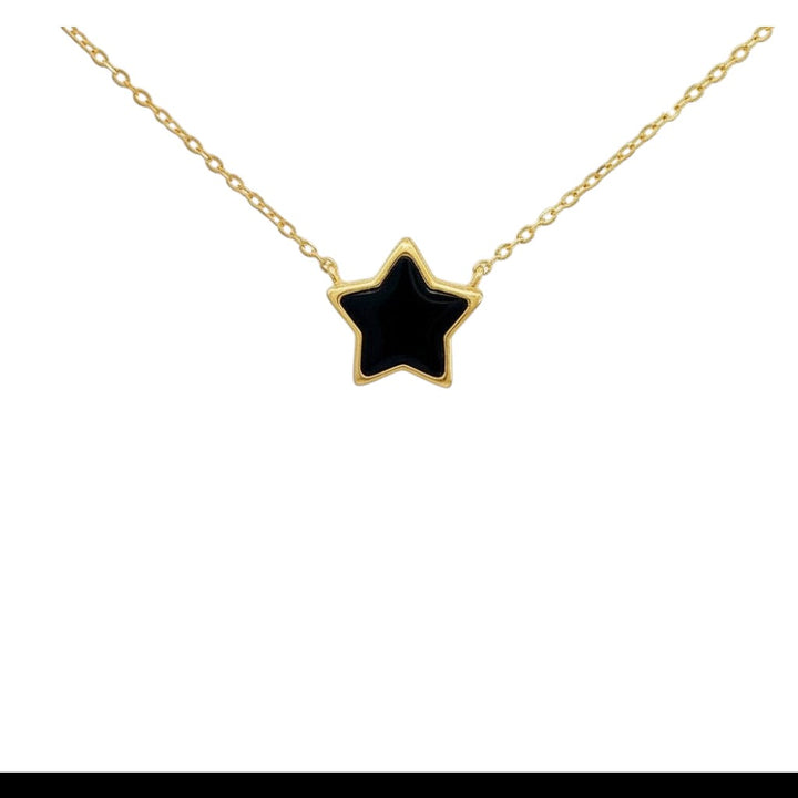 Caribbean Gems black onyx star pendant set in 14kt yellow gold on a delicate gold chain against a white background.