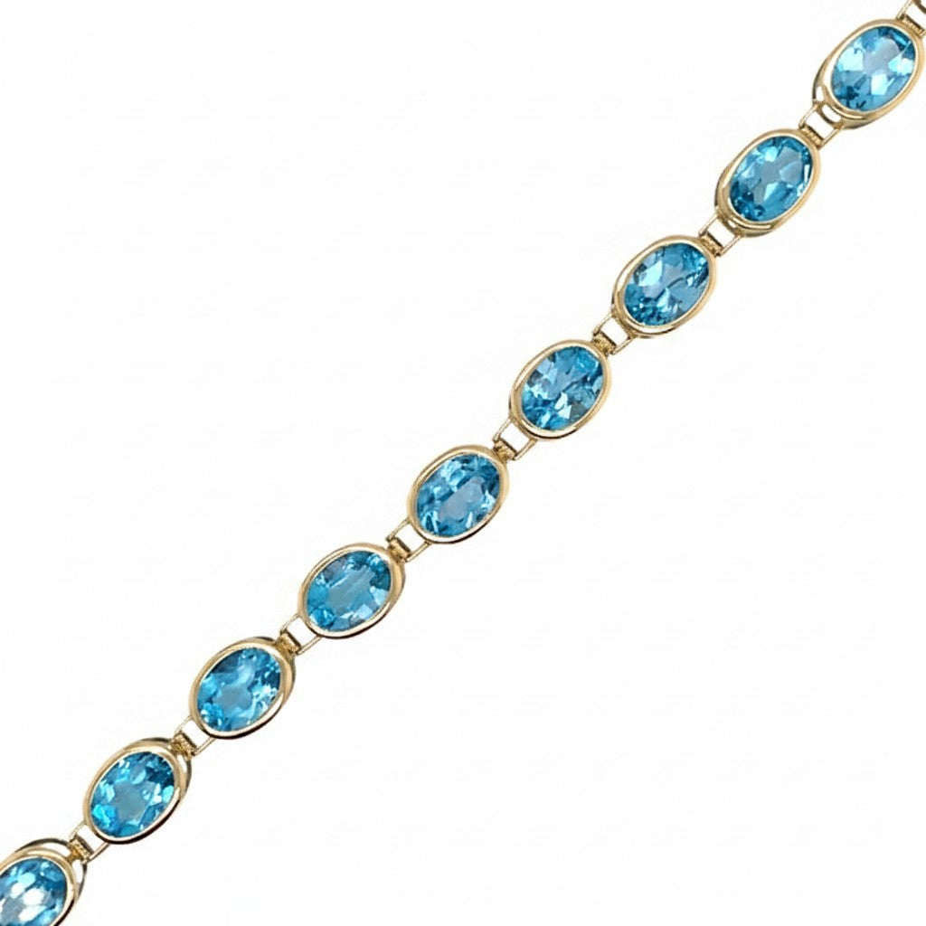 Caribbean Gems 14kt yellow gold bracelet featuring a series of vibrant oval blue topaz gemstones