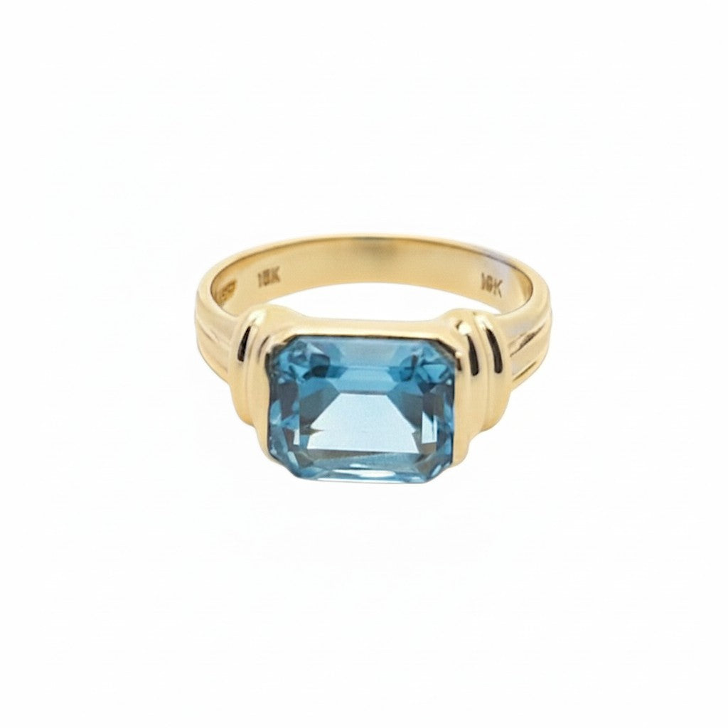 Caribbean Gems emerald-cut blue topaz ring set in 14kt yellow gold with a polished band.