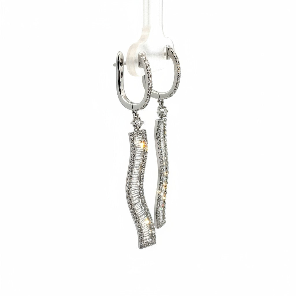Caribbean Gems dangling earrings in 18kt white gold with baguette and round cut diamonds on a display stand.