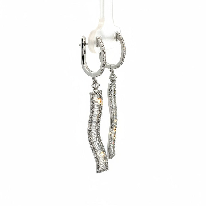 Caribbean Gems dangling earrings in 18kt white gold with baguette and round cut diamonds on a display stand.
