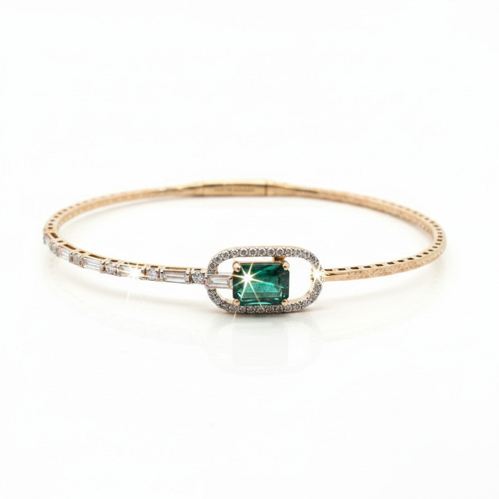 Caribbean Gems 14kt yellow gold bangle featuring a radiant cut emerald, baguette diamonds, and round brilliant stones.