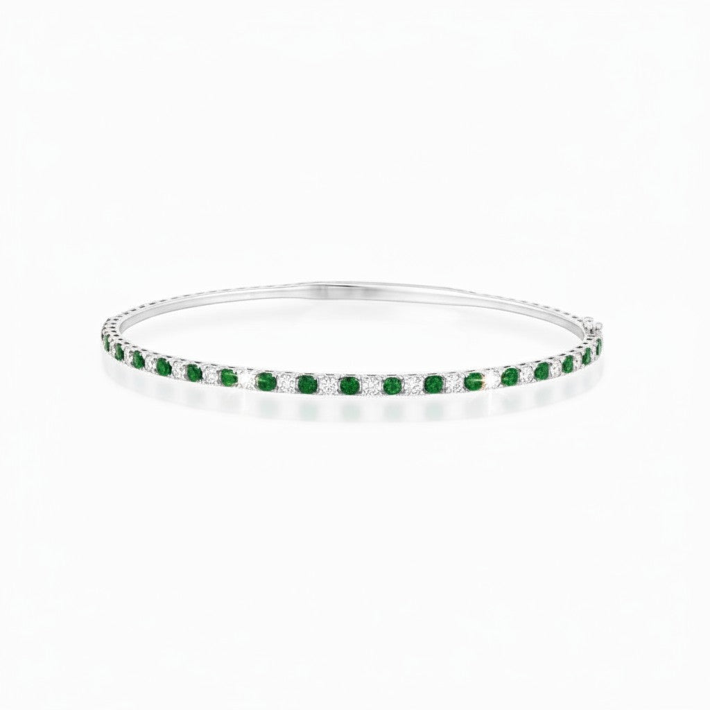 Caribbean Gems flexible 14kt white gold bangle featuring alternating round emeralds and diamonds