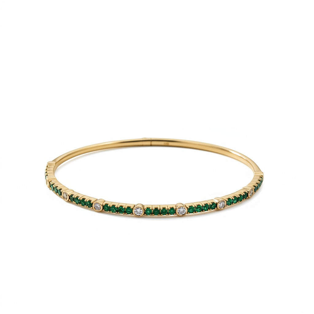 Caribbean Gems 14kt yellow gold bangle featuring a row of vibrant emeralds and sparkling round diamonds.