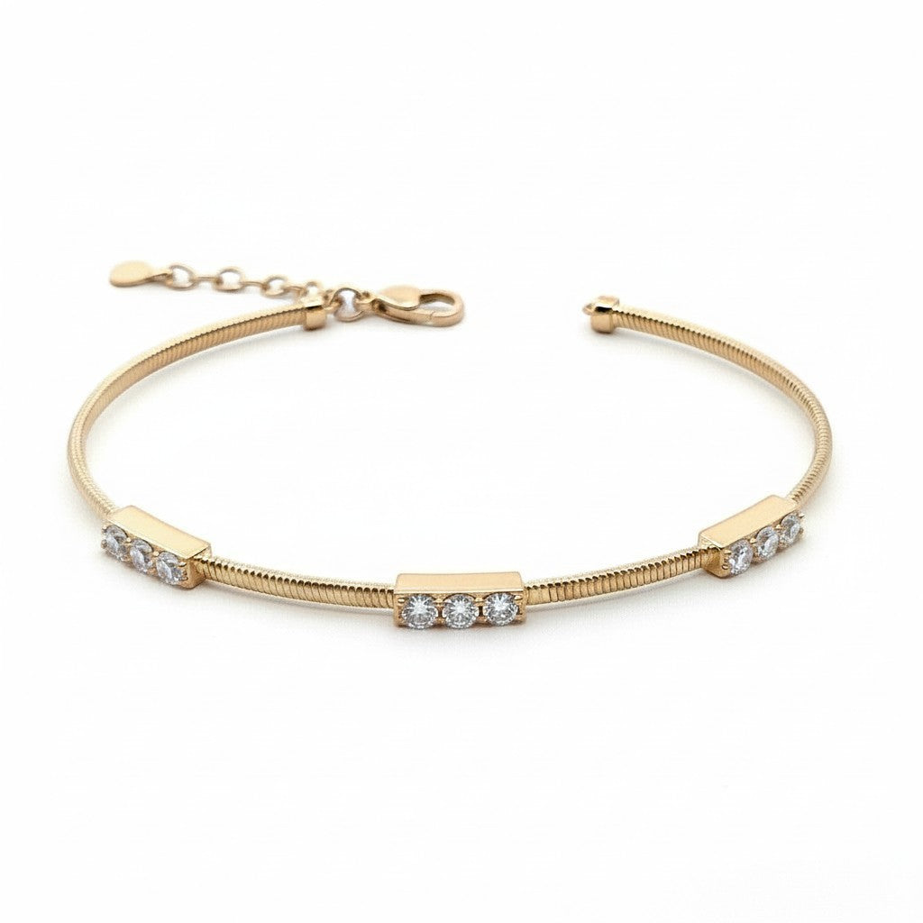 Caribbean Gems flexible 14kt yellow gold bangle featuring three diamond-set bars with round brilliant cut diamonds.