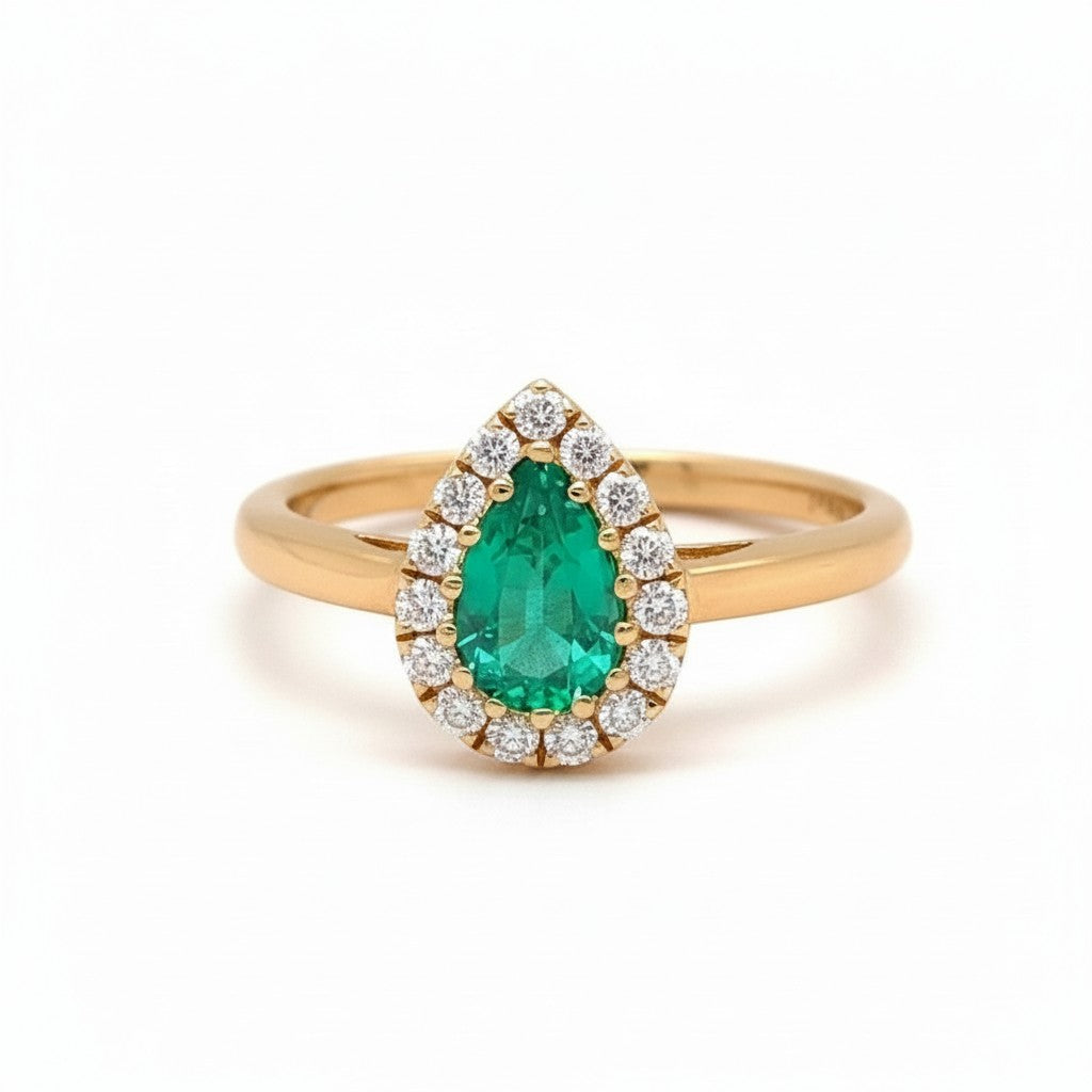 Caribbean Gems 14kt yellow gold ring with a 0.70ct pear-shaped emerald surrounded by a halo of round diamonds.