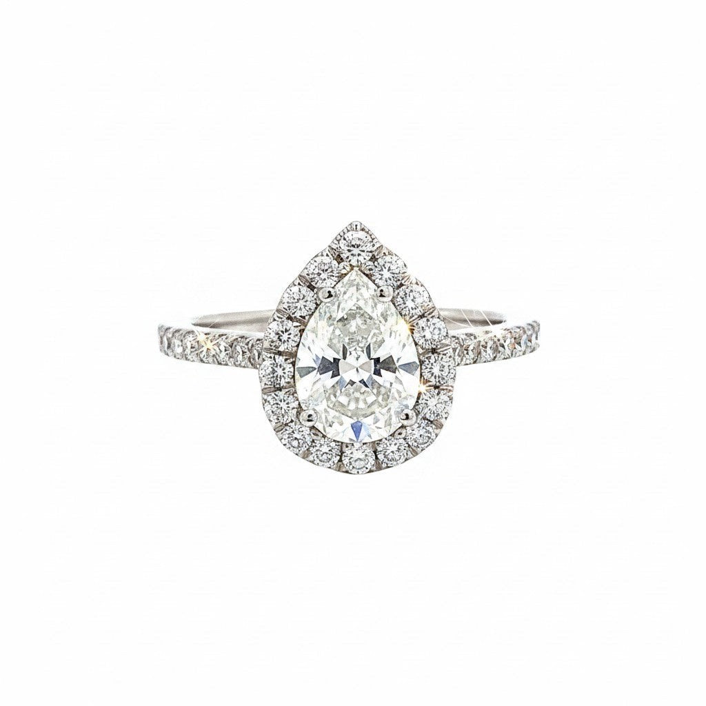 Caribbean Gems pear shape diamond engagement ring with a sparkling halo setting on a white background.