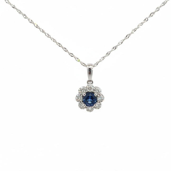 Caribbean Gems 14kt white gold pendant featuring a round sapphire surrounded by a halo of sparkling diamonds