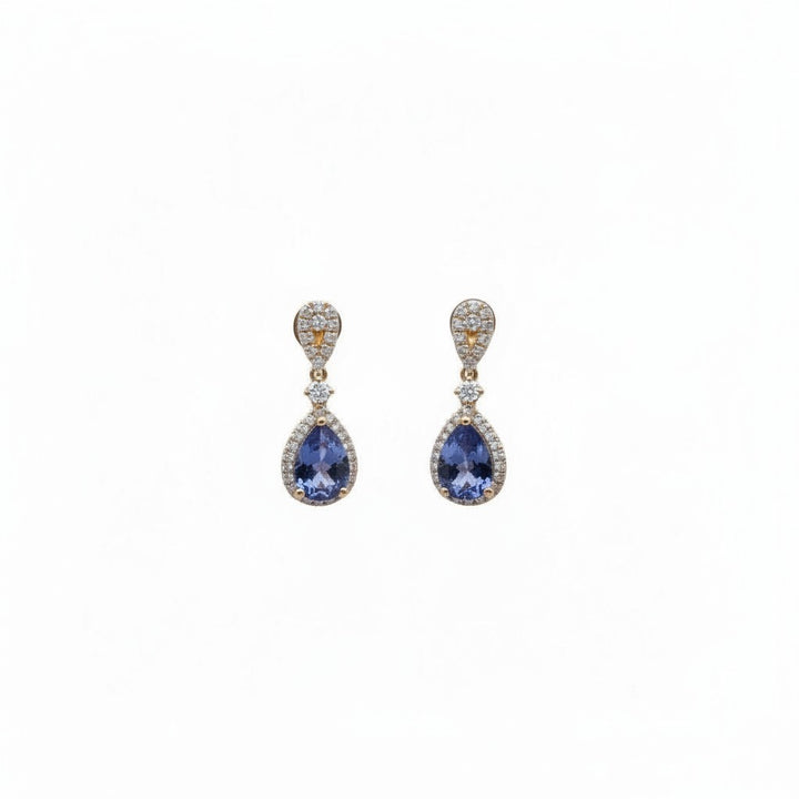Caribbean Gems ornate drop earrings featuring pear-cut tanzanite stones and diamond halos set in 18kt yellow gold.