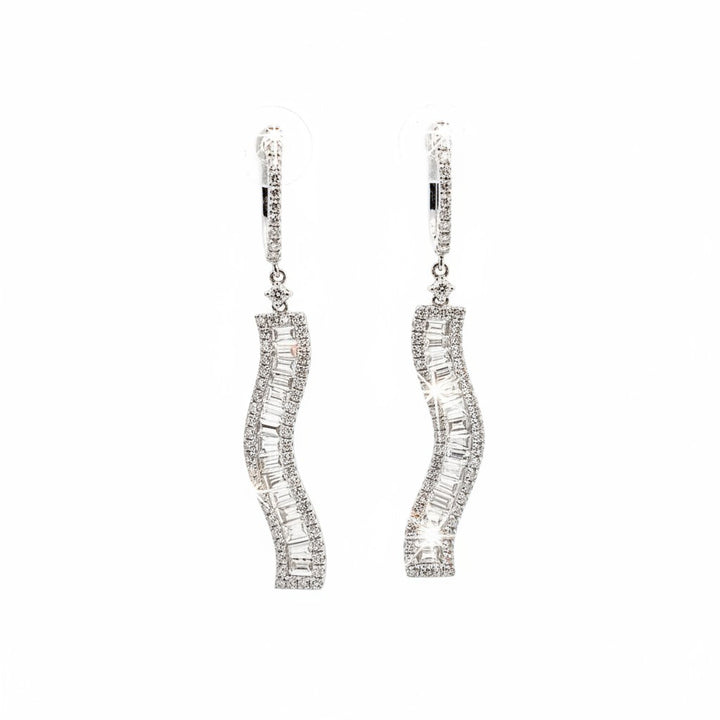 Caribbean Gems dangling earrings in 18kt white gold featuring baguette and round cut diamonds in a wavy design.